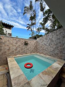 una piscina con un frisbee rojo. en Canto das Toninhas Guest House, en Ubatuba 30 fotos más
