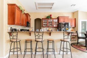 Una cocina con gabinetes de madera y taburetes de bar. en Rose Garden, en Sacramento