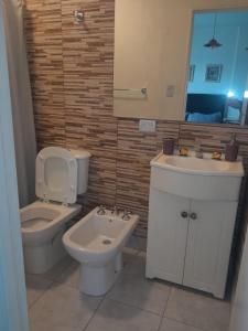 a bathroom with a toilet and a sink and a mirror at Microcentro Monoambiente Vista in Buenos Aires +23 photos