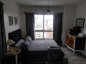 a bedroom with a bed and a large window at Microcentro Monoambiente Vista in Buenos Aires
