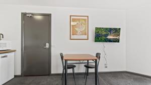 a table and chairs in a kitchen with a painting on the wall at Alpine Heights 18 in Mount Hotham