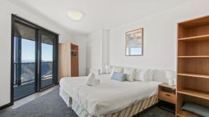 a bedroom with a large bed and a large window at Alpine Heights 18 in Mount Hotham +5 photos