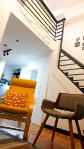a chair and a staircase in a room at 2-Bedroom Condotel Stay with Netflix, Kitchen & Washer, Near MRT Boni in Manila