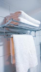 a bunch of towels on a rack in a bathroom at 2-Bedroom Condotel Stay with Netflix, Kitchen & Washer, Near MRT Boni in Manila