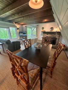 a living room with a table and chairs and a fireplace at Killington A-Frame home in Killington +21 photos
