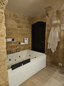 a bathroom with a white tub and a black door at Casa Petra Bari in Bari