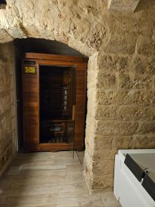 a room with a brick wall and a wooden door at Casa Petra Bari in Bari