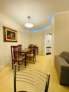 a living room with a table and chairs and a couch at Apto com cozinha e lavanderia in Joinville +20 photos