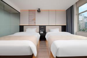 Postel nebo postele na pokoji v ubytování Jiduo Cinema Hotel