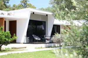 a white house with two chairs in the yard at Luna Mare Boutique Seaside in Borsh