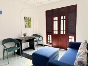a living room with a blue couch and a table and chairs at Sonora in Kandy