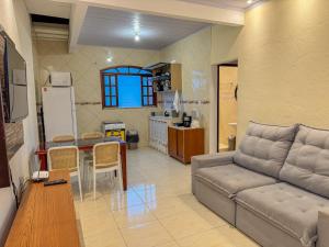 ein Wohnzimmer mit Sofa und Tisch in der Unterkunft Casa na prainha de Mambucaba. Uma quadra do mar. in Paraty