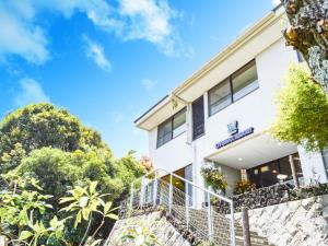 a white building on a hill with trees at LiVEMAX RESORT izukogen in Ito