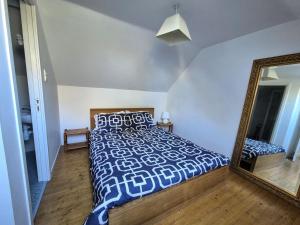a bedroom with a bed and a mirror at Tranquil Cottage, Maël-Carhaix in Maël-Carhaix