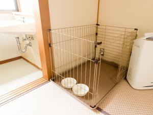 a bathroom with a cage next to a sink at LiVEMAX RESORT izukogen in Ito