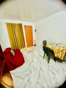 a bedroom with a large bed and a table with a red blanket at Budget-StudioRoom-Panabo-Homestay in Panabo