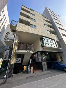 ein Gebäude mit einem blauen Auto, das davor geparkt ist in der Unterkunft NewOpenSapporo TanukikojiShimaya Building403 in Sapporo