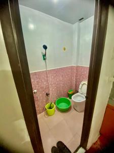a bathroom with a toilet and buckets in it at Budget-StudioRoom-Panabo-Homestay in Panabo +2 photos