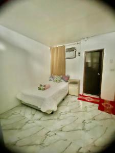 a bedroom with a bed with a marble floor at Budget-StudioRoom-Panabo-Homestay in Panabo