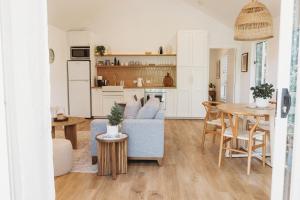 a living room with a blue couch and a table at Private & Stylish Hinterland Cottage in Gold Coast