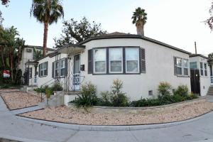 a white house with palm trees in front of it at Charming studio city Bungalow in Los Angeles