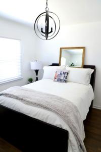 a bedroom with a black and white bed with a chandelier at Charming studio city Bungalow in Los Angeles