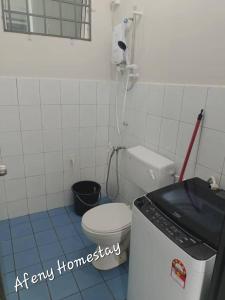 a bathroom with a toilet and a washing machine at Afeny Homestay in Tawau +5 photos