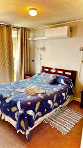 Un dormitorio con una cama con un edredón azul. en Apartamento Vista Buena, en Talca