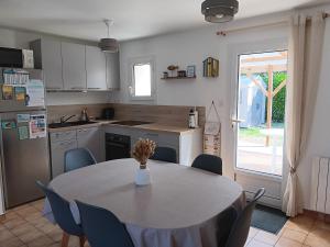 a kitchen with a table and a kitchen with a table and chairs at Maison plain-pied au calme, proche plages et commerces - FR-1-476-91 in La Faute-sur-Mer
