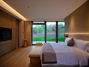 天台Ruolinqiao Valley Garden Hotel的一间大卧室,配有一张大床和一个大窗户