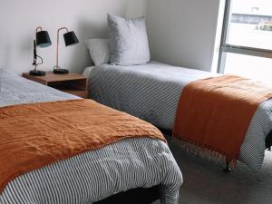 Un dormitorio con dos camas y una ventana. en Family Friendly - Close to new stadium, en Christchurch