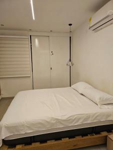 Un dormitorio con una gran cama blanca en una habitación. en Santa Marta Family Home, en Santa Marta