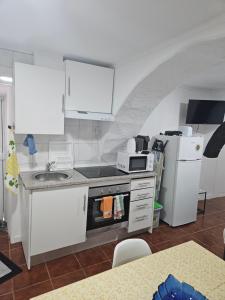 a kitchen with a sink and a stove top oven at Casa da Mina in Ponta Delgada