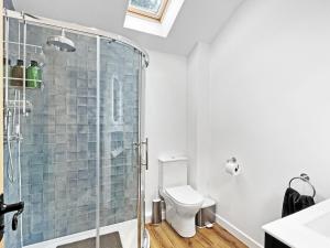 a bathroom with a shower and a toilet at Byre Cottage Dulverton in Dulverton +22 photos