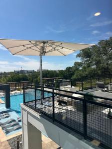 a balcony with an umbrella and a swimming pool at Pinky in Austin