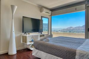 a bedroom with a large bed and a large window at SkyView Manquehue in Santiago