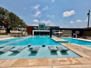 a large swimming pool with chairs in a building at Pink Couture in Austin