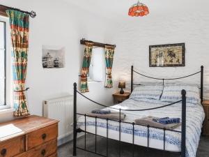 a bedroom with a bed and a desk and a window at Barn Cottage - Uk47089 in Davidstow