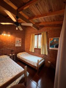 a bedroom with two beds and a ceiling fan at Casa La Selva in Ostende