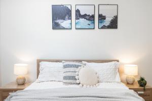 a bedroom with a bed with four pictures on the wall at Port Melbourne Victorian Cottage in Melbourne