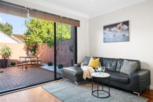 a living room with a couch and a table at Port Melbourne Victorian Cottage in Melbourne