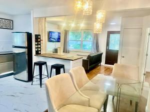 a kitchen and living room with a glass table and chairs at Escapade Marie-Isabelle in Montreal