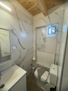 a bathroom with a sink and a toilet and a mirror at Avra Benitses Beach Apartment in Benitses +26 photos