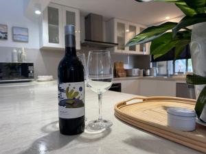 a bottle of wine and a wine glass on a table at Peppermint Grove Beach Holiday Park in Capel