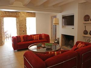 a living room with red couches and a table at Mansion in Castellnou near Pedraforca Mountains in Castellnou de Bages