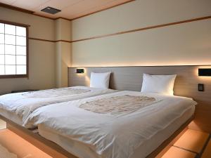 Postel nebo postele na pokoji v ubytování Komakusa Hotel