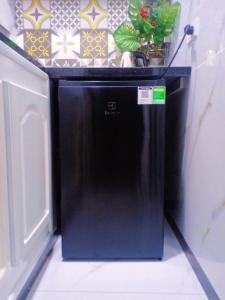 a black refrigerator with a plant on top of it at Hoàng Nga 2 Homestay in Phan Thiet