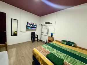 a bedroom with a bed and a flat screen tv at Tu Estancia en Sonsonate in Sonsonate