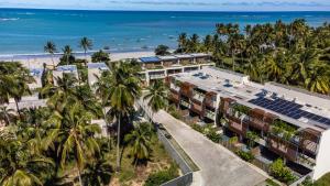 an aerial view of a resort with palm trees and the beach at Casa Bangalô dos Milagres in Passo de Camarajibe