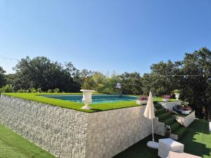a backyard with a stone wall and a swimming pool at TRULLI ALLEGRETTI in Noci